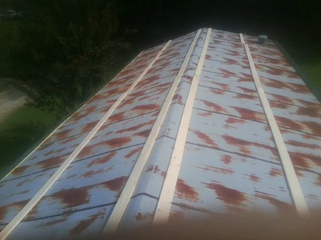 Rusted metal roof panels with new wood purlins before replacement — Storm Damage Roof Repair in Eldena by Roofing Brothers